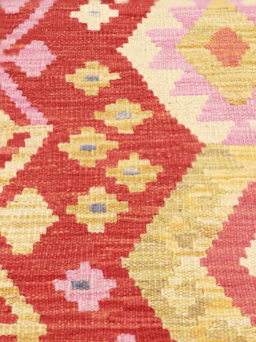 Hand-woven Afghan Kelim rug with red field and geometric diamond patterns