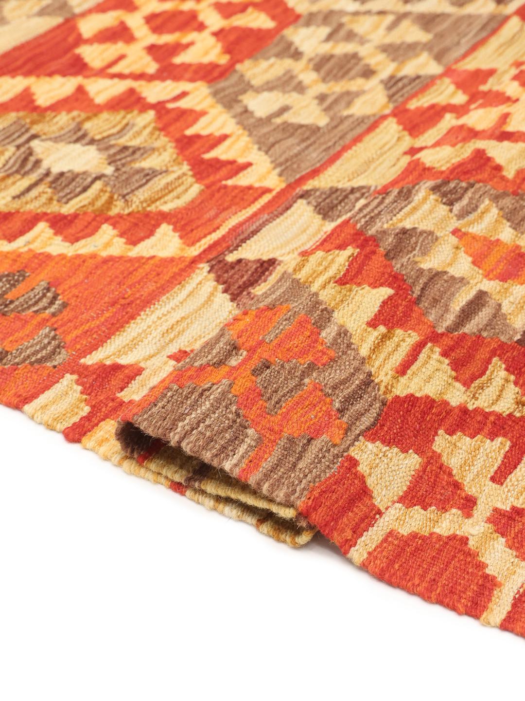 A hand-woven Afghan Kelim rug featuring geometric patterns in red, orange, and beige.