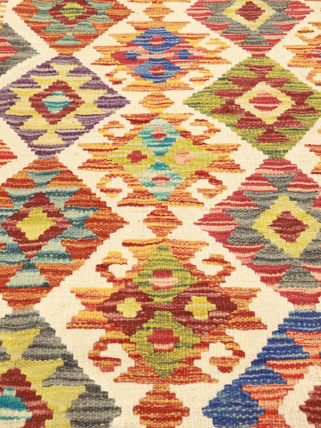Hand-woven Afghan Kelim rug featuring a colourful geometric diamond pattern in multicolor tones.