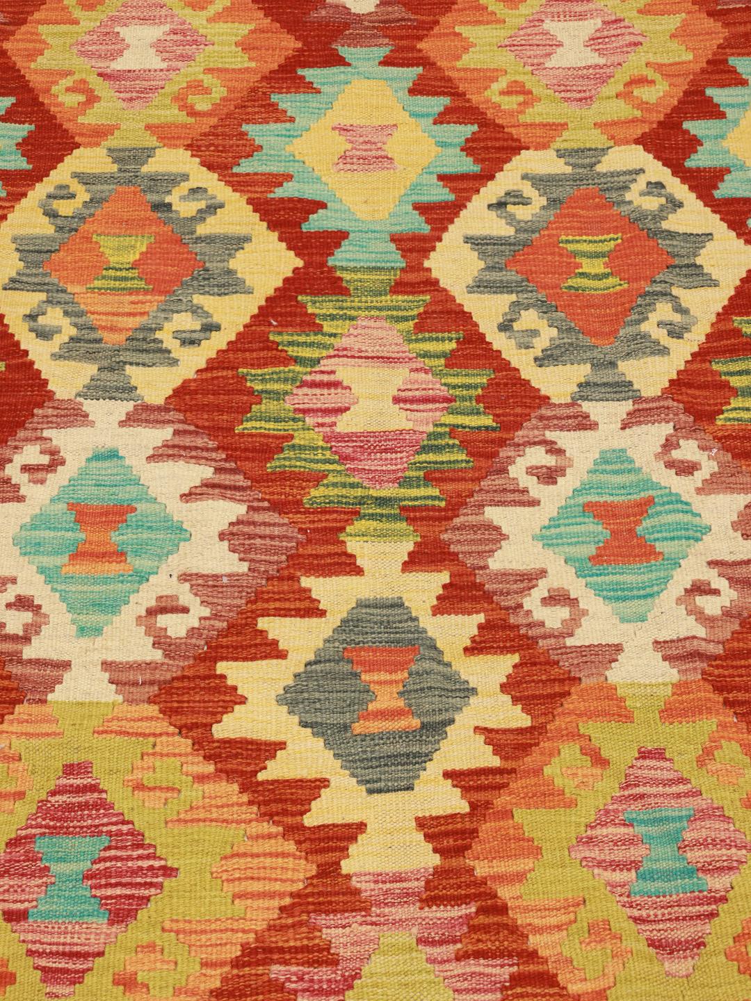 Een groot rechthoekig Afghaans Kelim-tapijt met een levendig geometrisch ruitpatroon in multicolor.