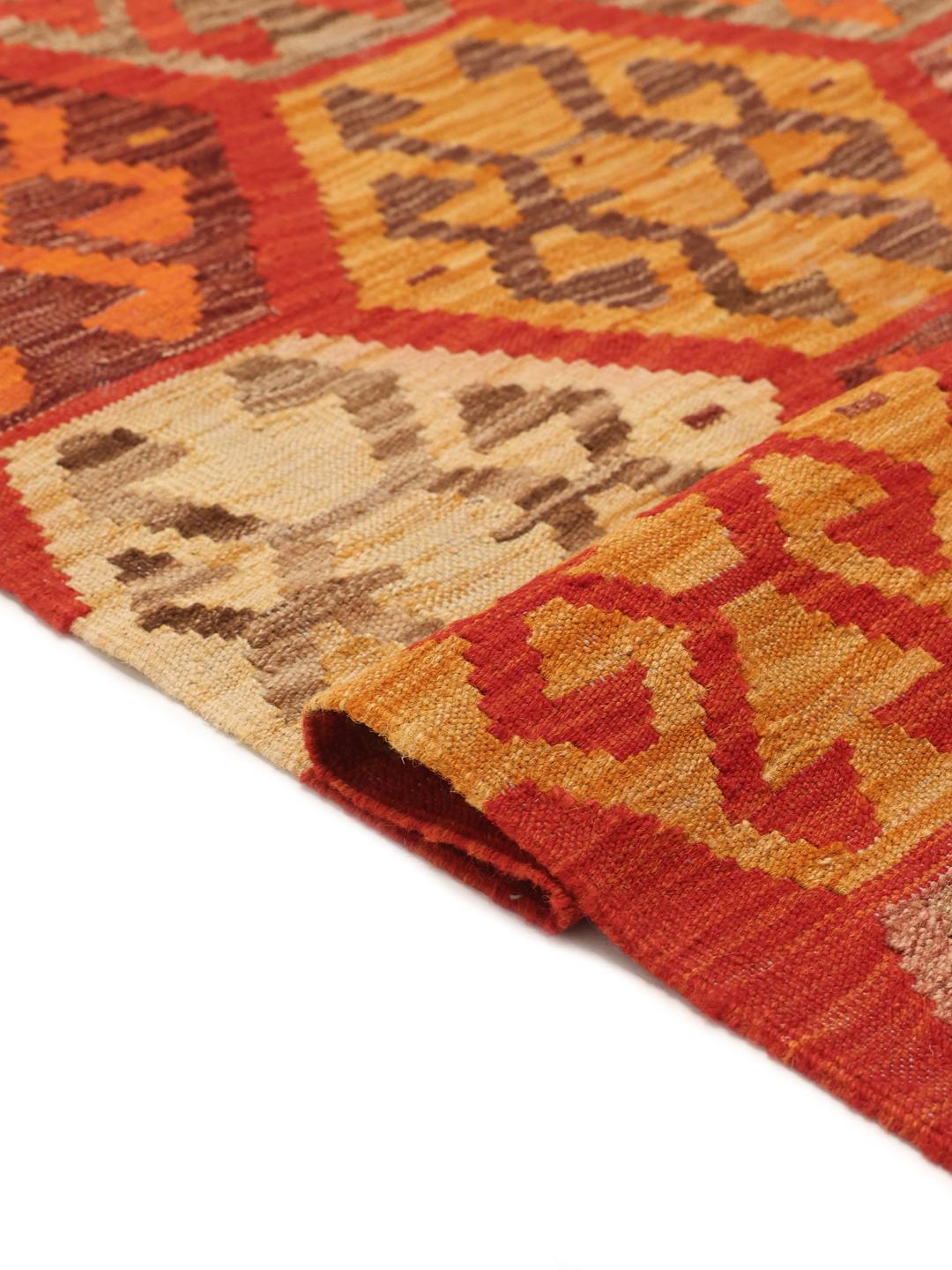 Een groot handgeweven Afghaans Kelim vloerkleed met een levendig rood veld en geometrische honingraatmotieven.