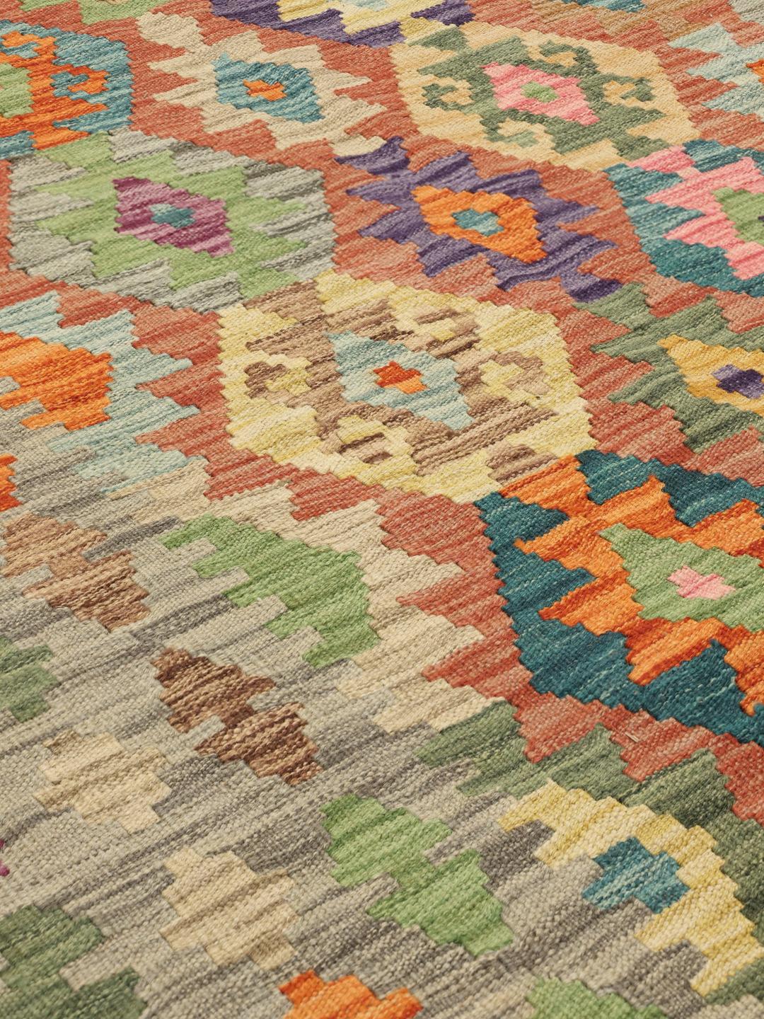 Een groot handgeweven Kelim Afghan Old Style tapijt met een levendig veelkleurig geometrisch patroon op een wollen basis.