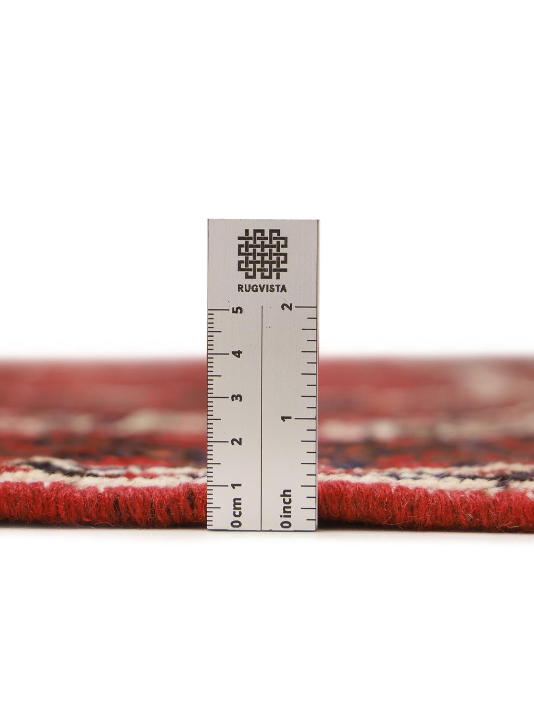 Hand-knotted Shiraz rug from the Middle East featuring a dark-red field with geometric medallions