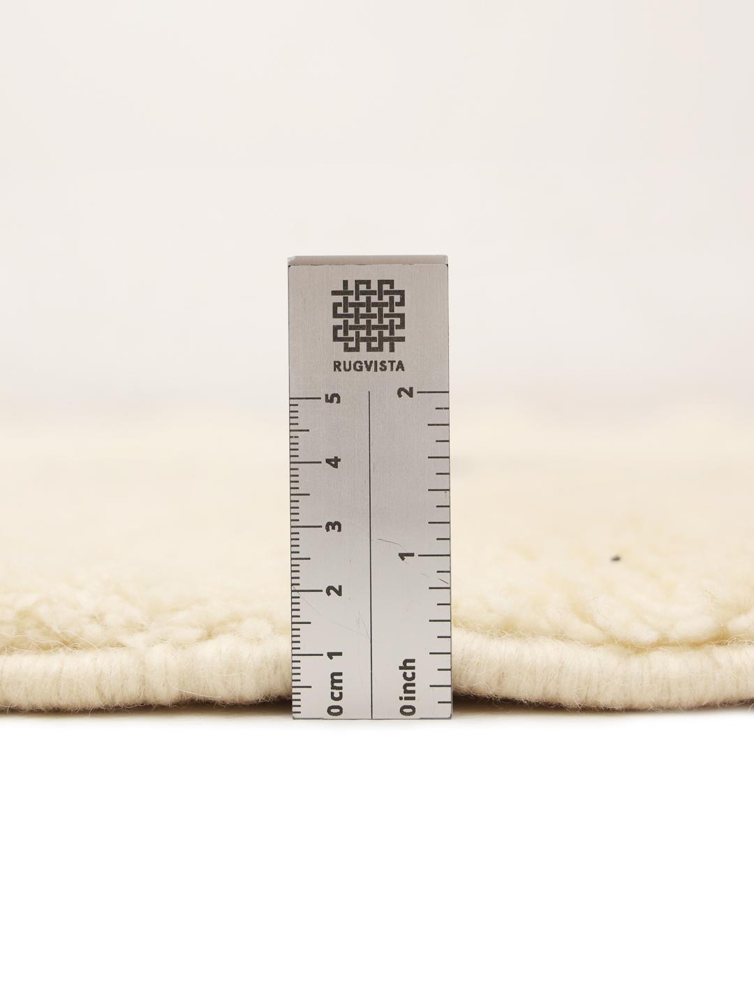 Et rektangulært håndlavet marokkansk berbertæppe med en beige baggrund og et sort diamantmønster.