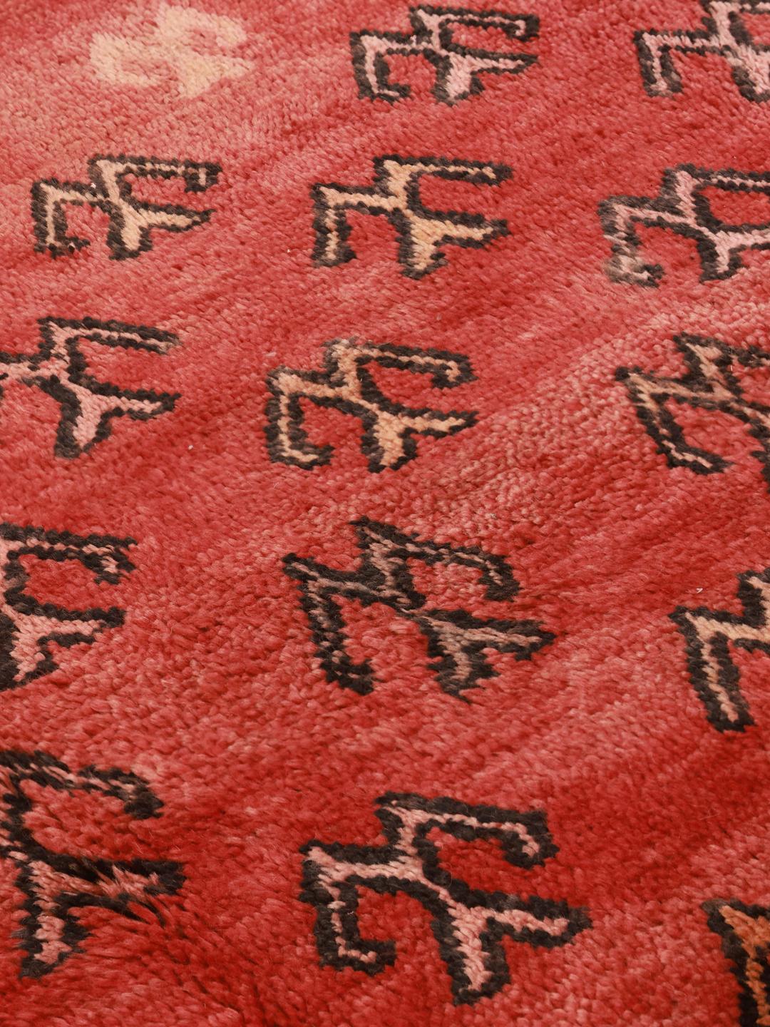 Vintage håndknyttet marokkansk tæppe med geometriske motiver på rød baggrund