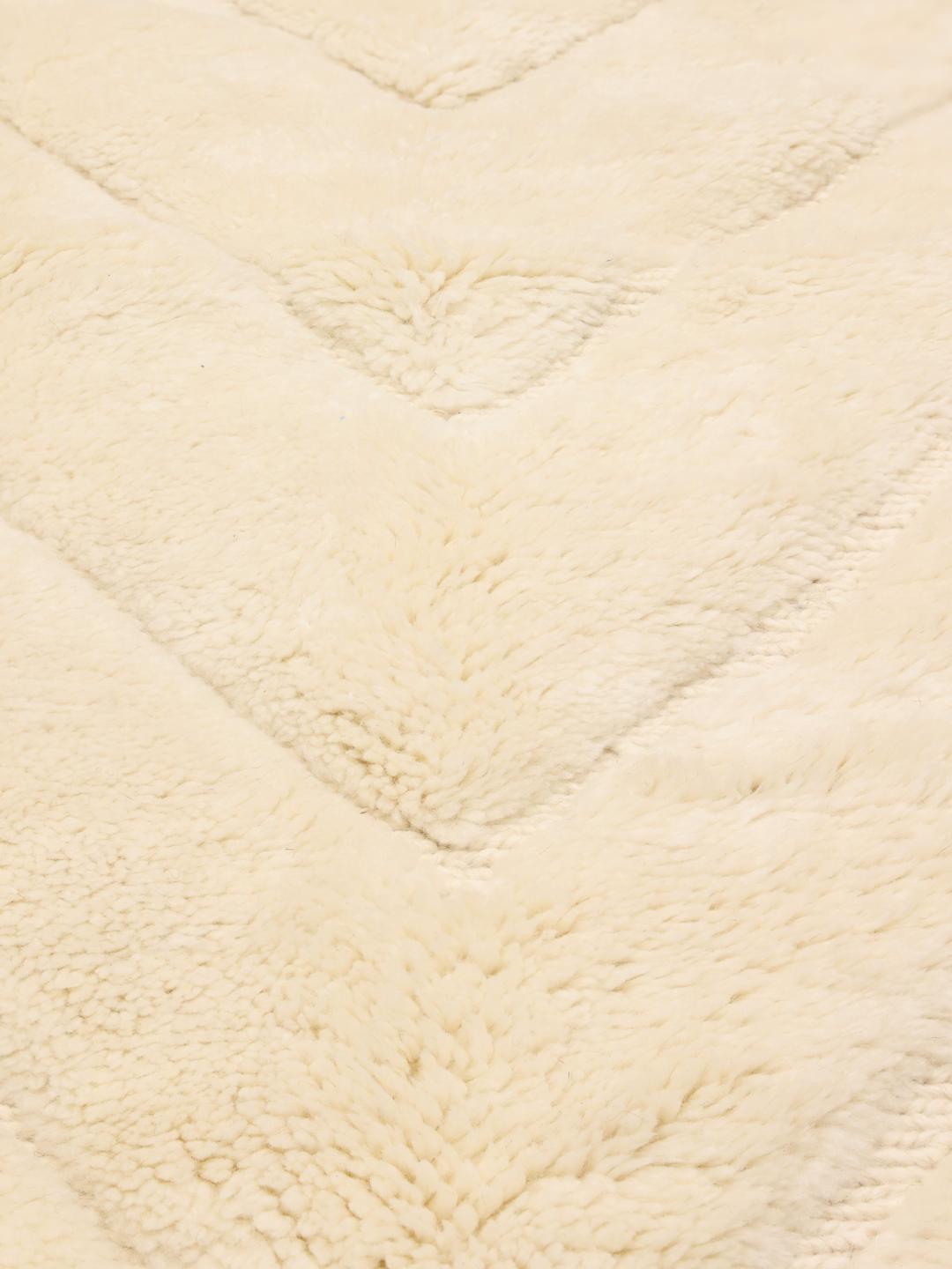 Et håndknyttet marokkansk berbertæppe med et minimalistisk diamantmønster i beige.