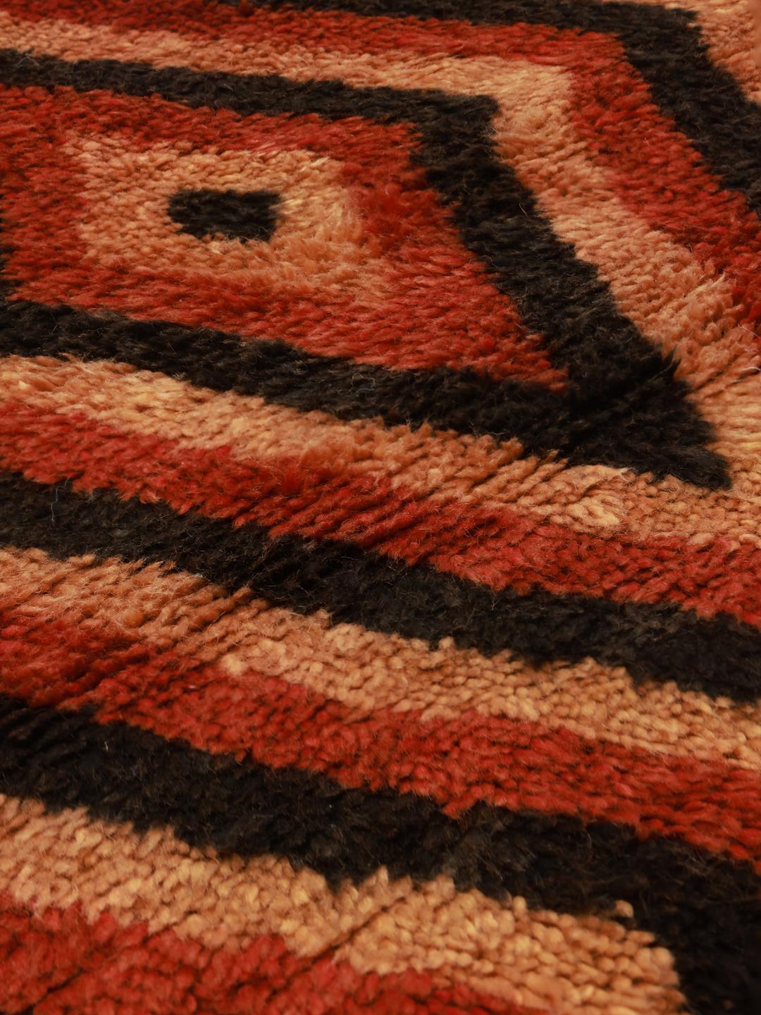 Vintage Berber Marokkaans tapijt uit Marokko met een levendig rood en zwart ruitpatroon.