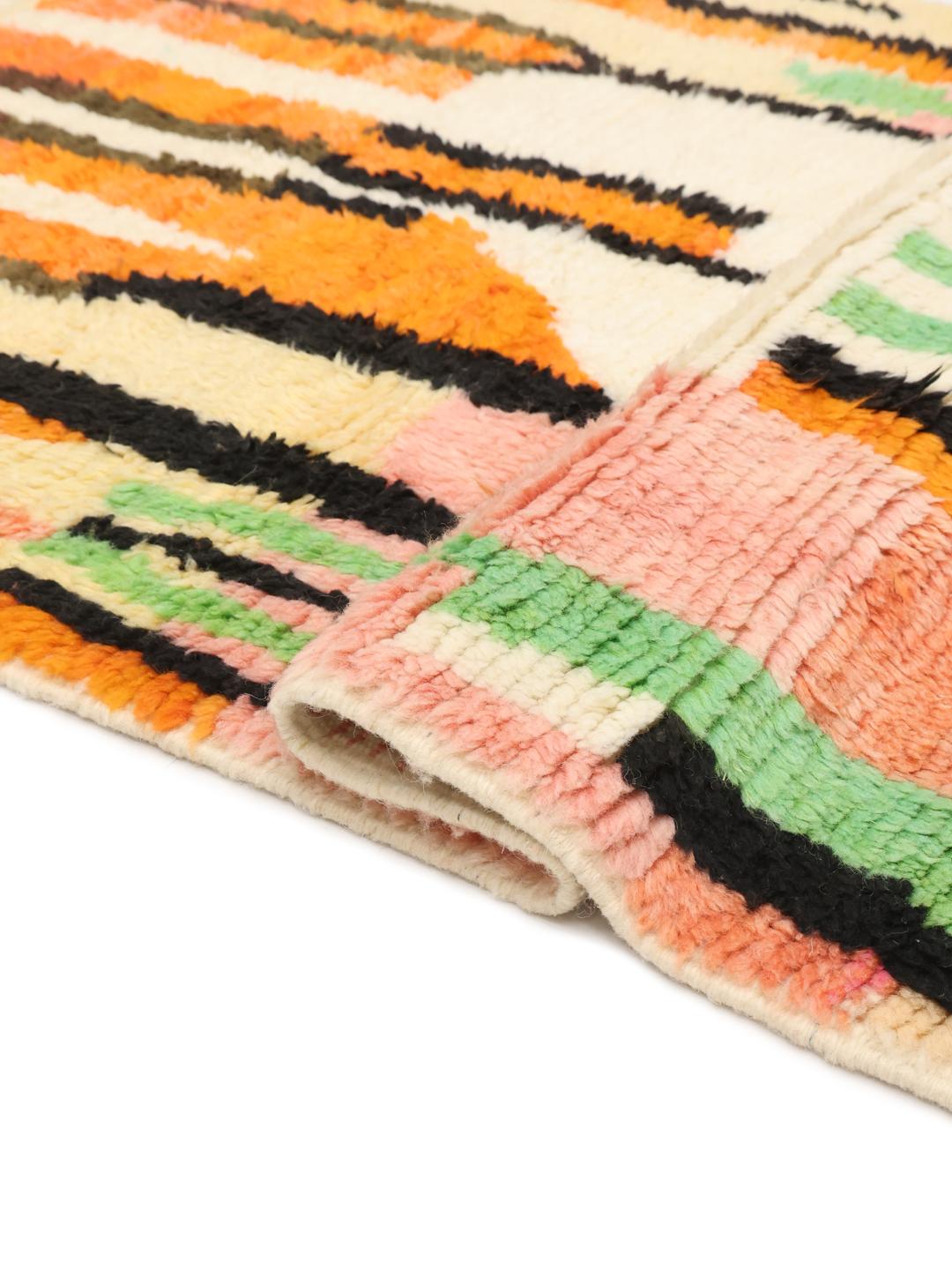 Een levendig, handgeknoopt Marokkaans Berber tapijt met abstracte motieven en felle kleuren.