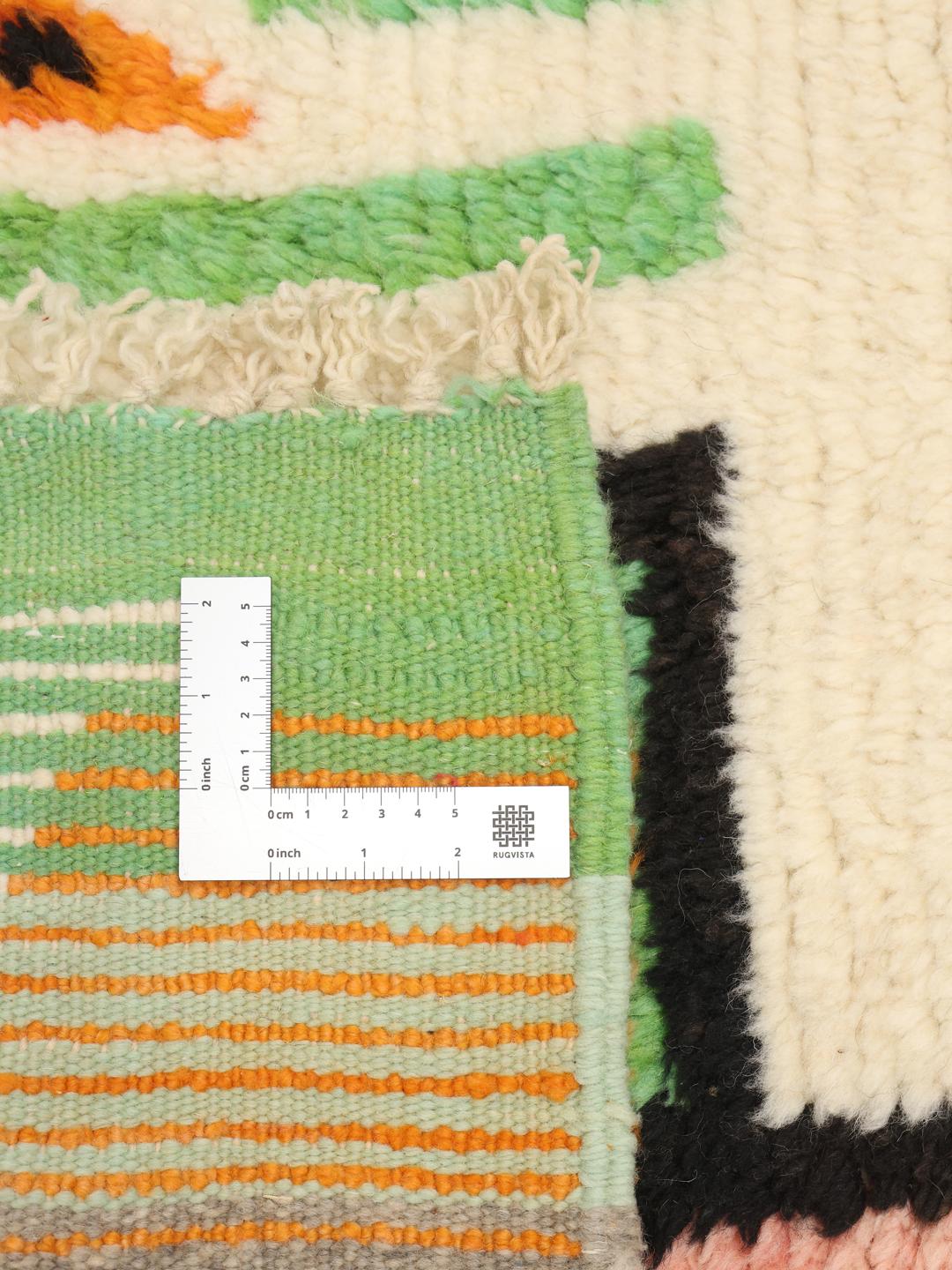 Een levendig, handgeknoopt Marokkaans Berber tapijt met abstracte motieven en felle kleuren.