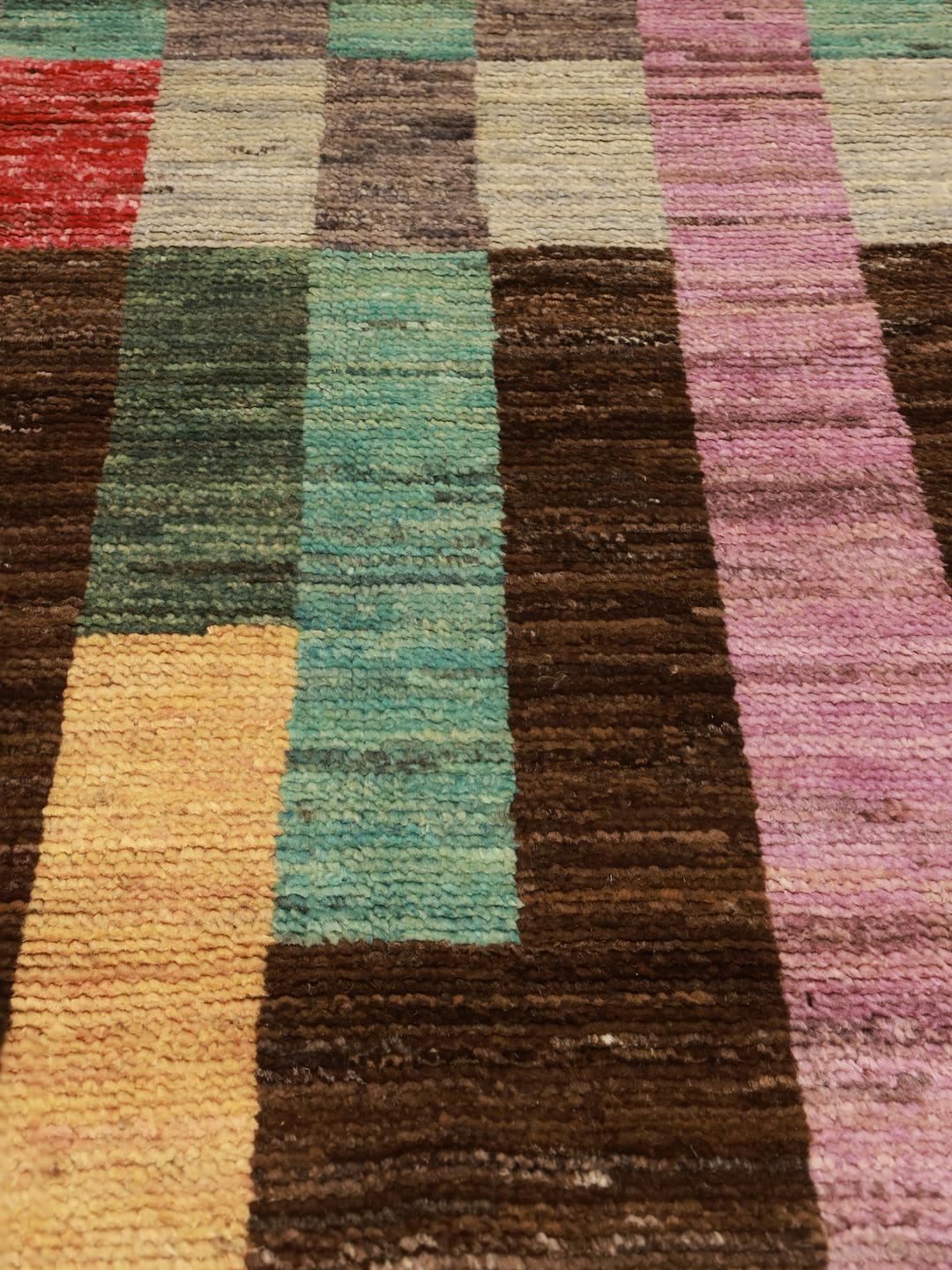En färgglad handknuten afghansk matta med ett geometriskt blockmönster i Wool
