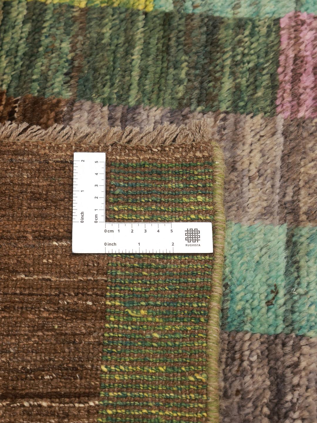 En färgglad handknuten afghansk matta med ett geometriskt blockmönster i Wool