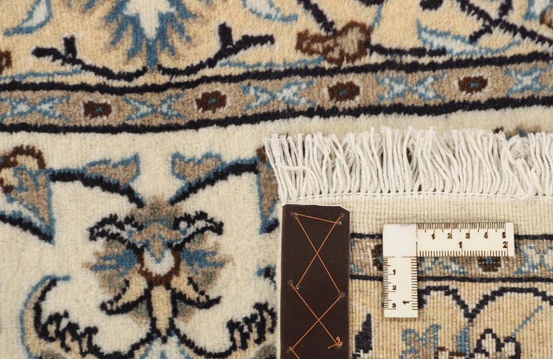 Hand-knotted Nain rug from the Middle East with a beige and blue floral pattern.