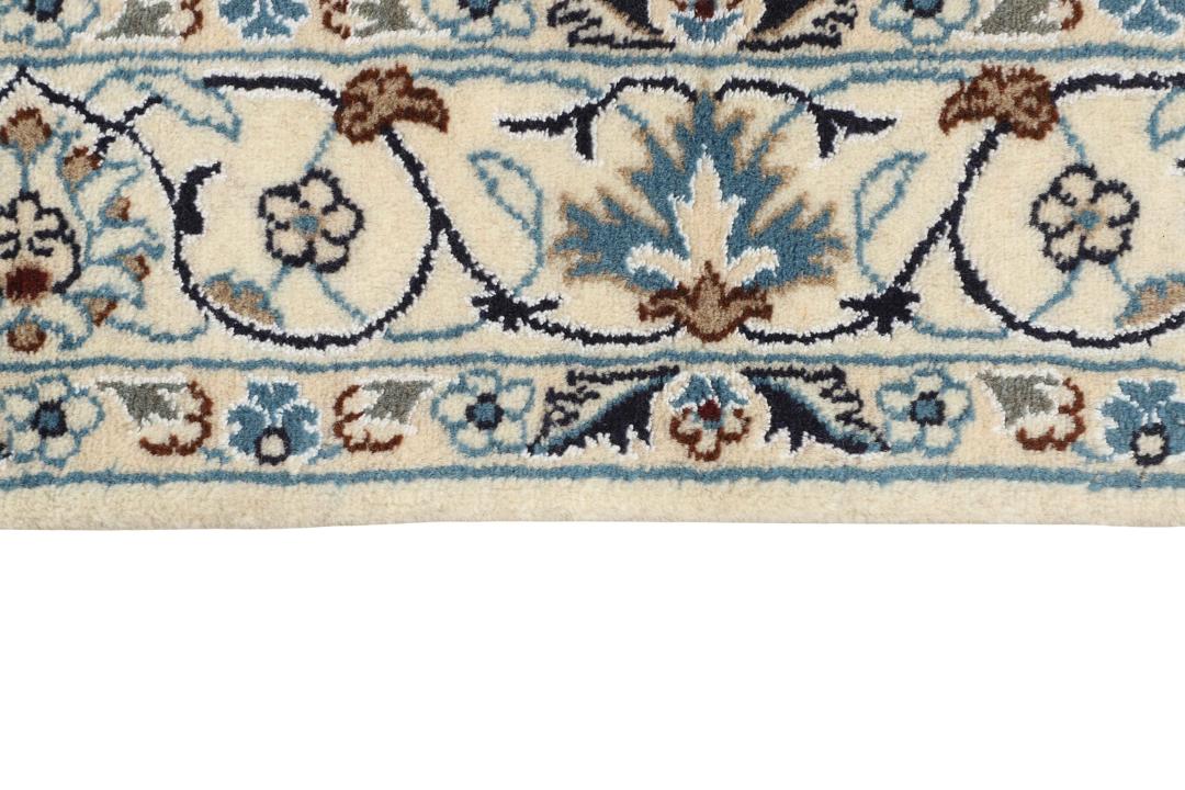 Hand-knotted Nain rug from the Middle East with a floral medallion on a beige background.