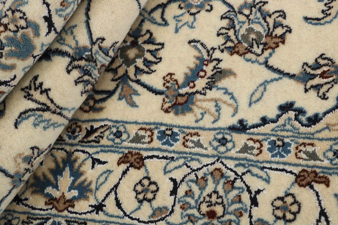 Hand-knotted Nain rug from the Middle East with a floral medallion on a beige background.