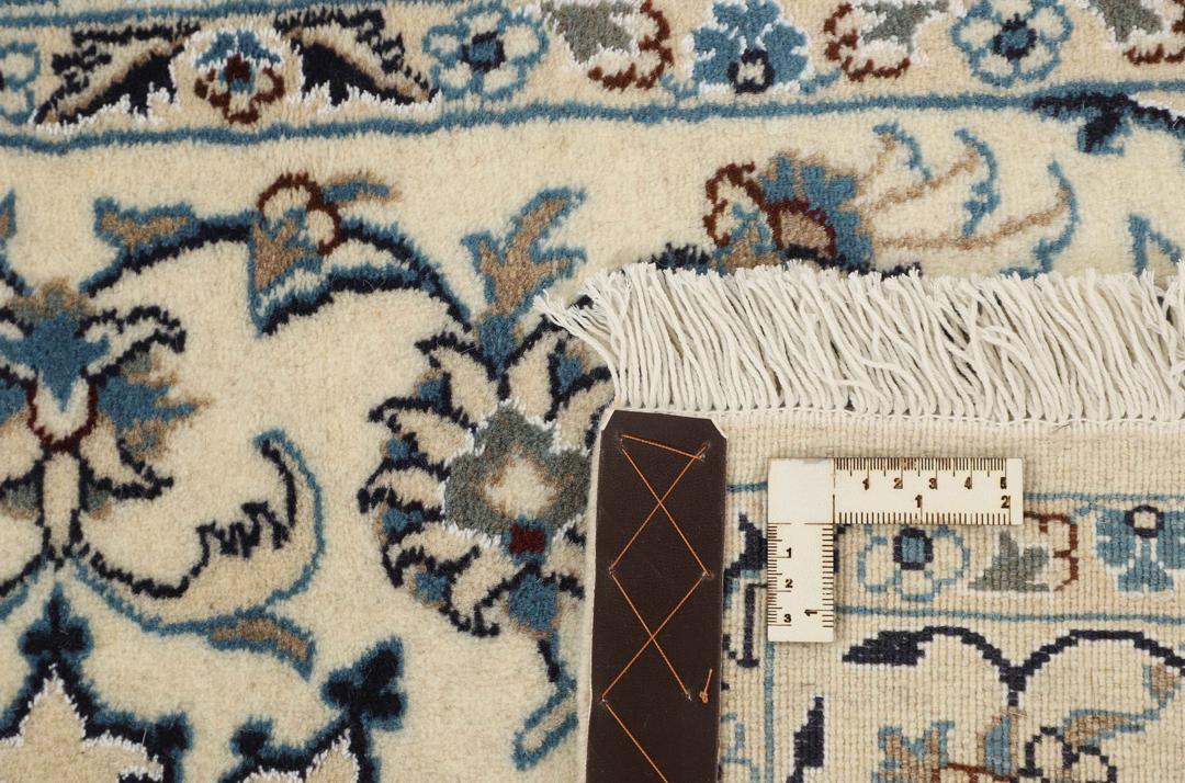 Hand-knotted Nain rug from the Middle East with a floral medallion on a beige background.