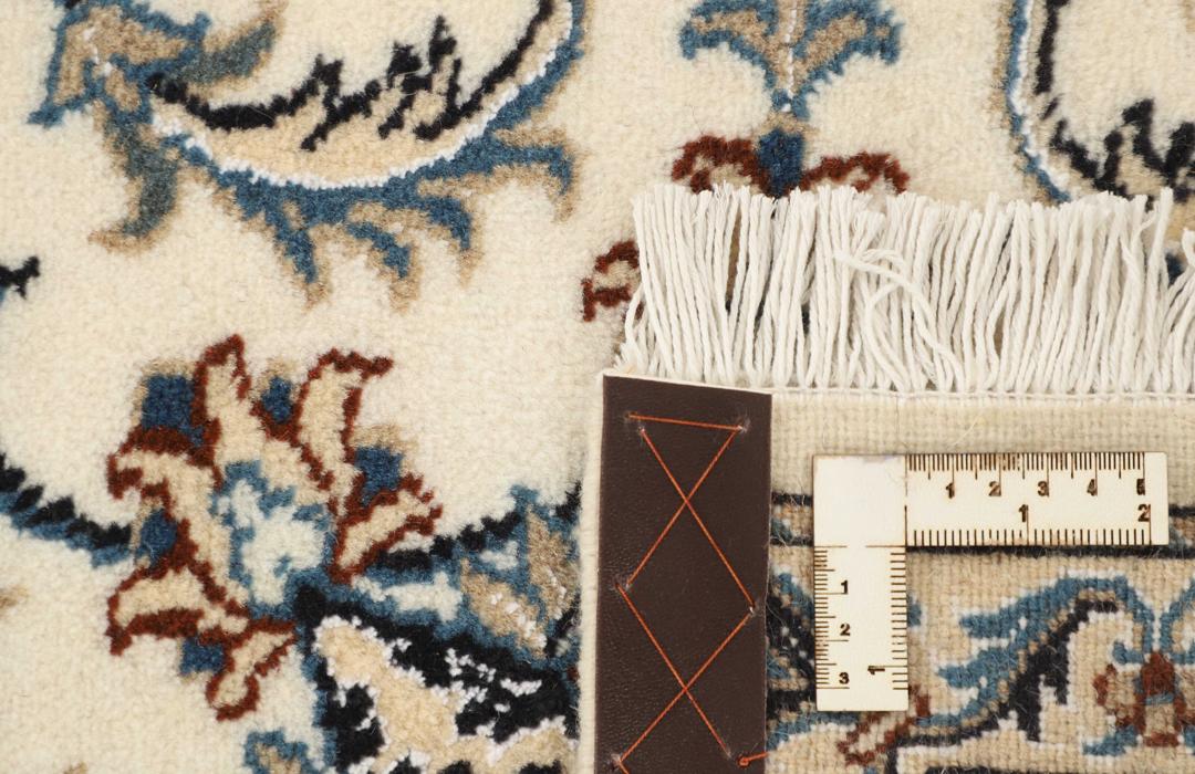 Hand-knotted Nain runner with a beige field and floral motifs in blue and earth tones