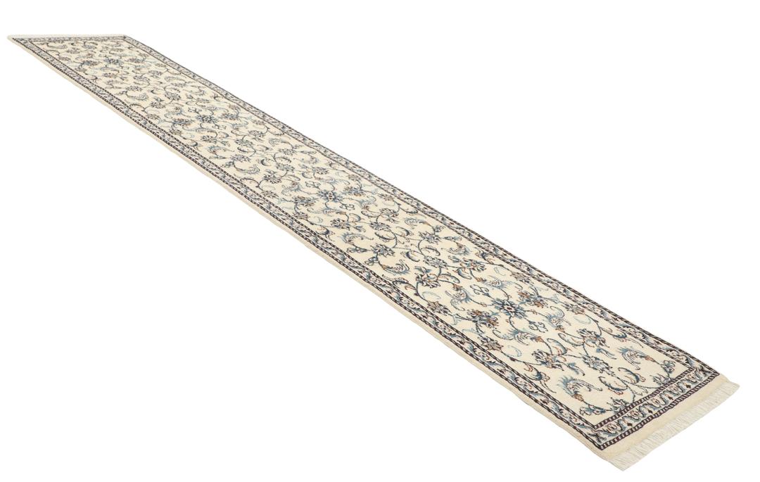 En håndknyttet beige løber med indviklede blå og blomstrede mønstre fra Mellemøsten
