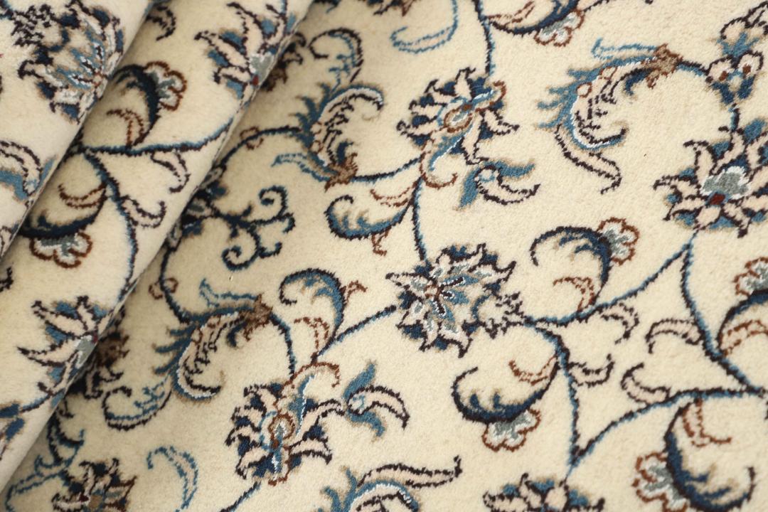 En håndknyttet beige løber med indviklede blå og blomstrede mønstre fra Mellemøsten
