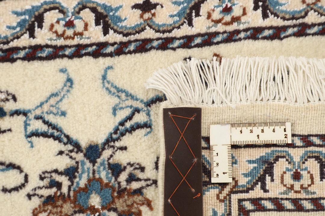 En håndknyttet beige løber med indviklede blå og blomstrede mønstre fra Mellemøsten