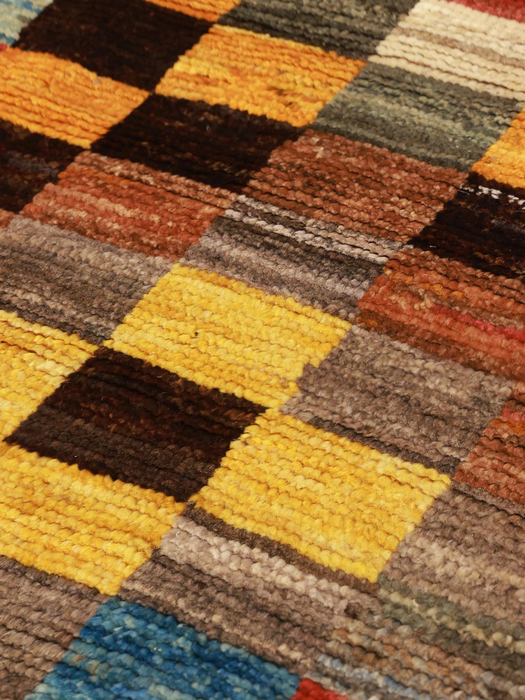 Een met de hand geknoopt Berber-tapijt uit Afghanistan met een kleurrijk geometrisch dambordpatroon.