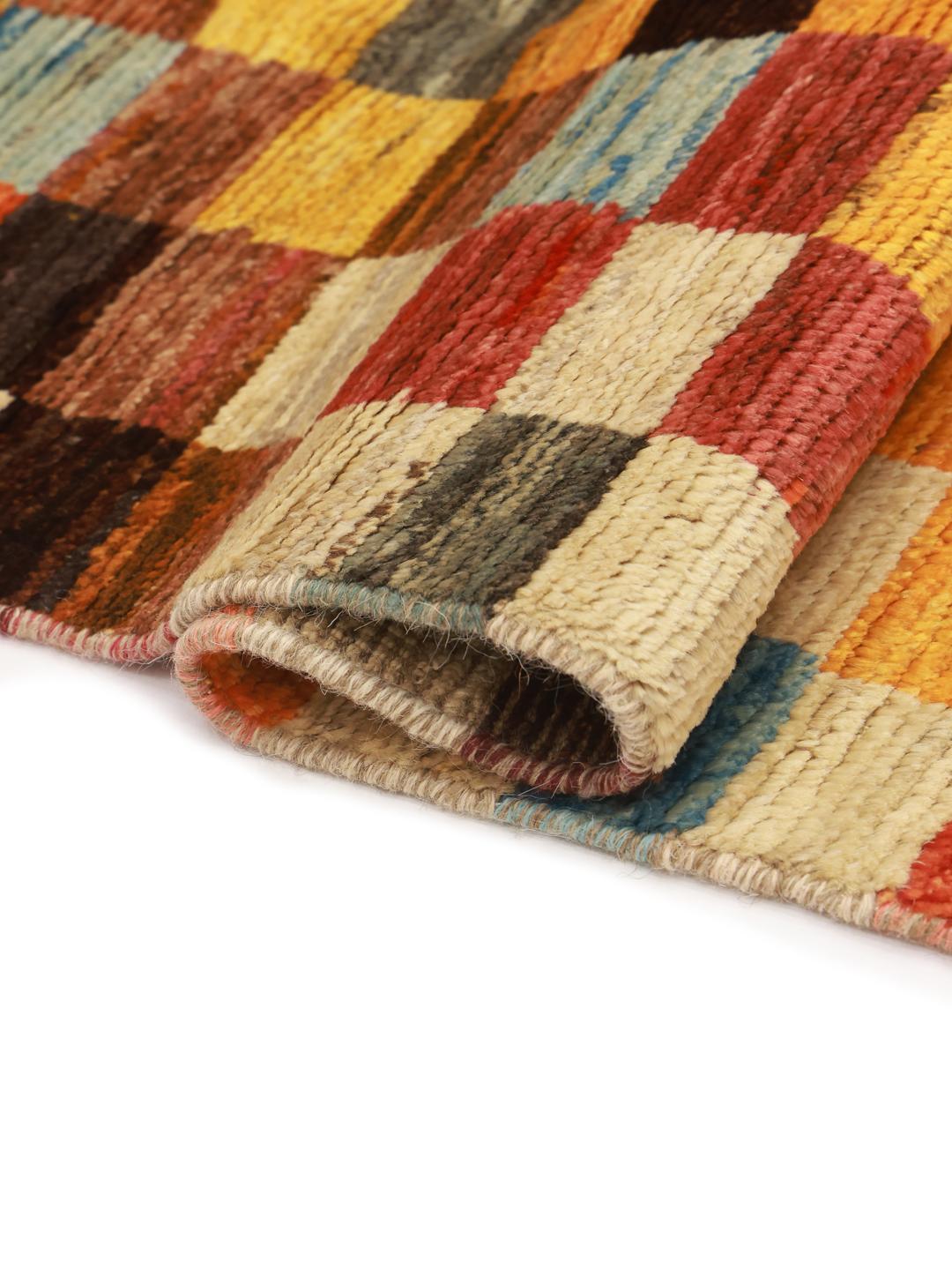 Een met de hand geknoopt Berber-tapijt uit Afghanistan met een kleurrijk geometrisch dambordpatroon.