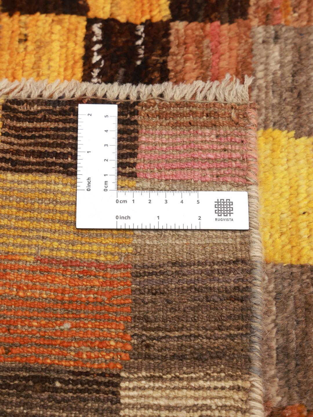 Een met de hand geknoopt Berber-tapijt uit Afghanistan met een kleurrijk geometrisch dambordpatroon.