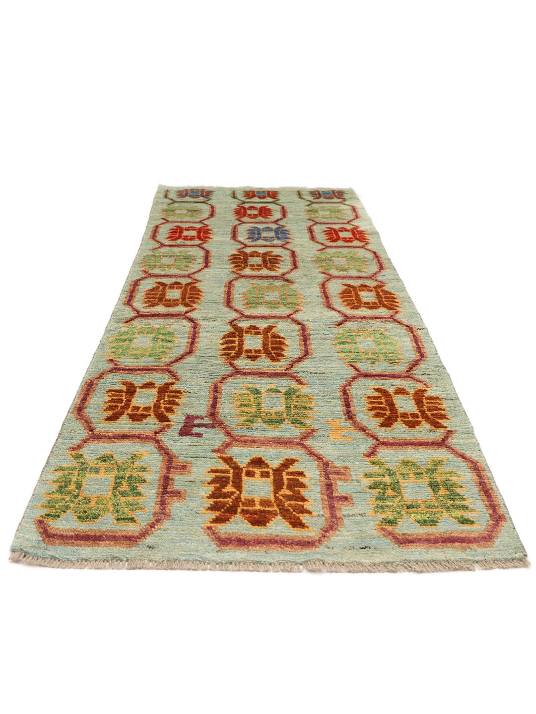 A hand-knotted Afghan runner with a vibrant geometric pattern on a light blue background.