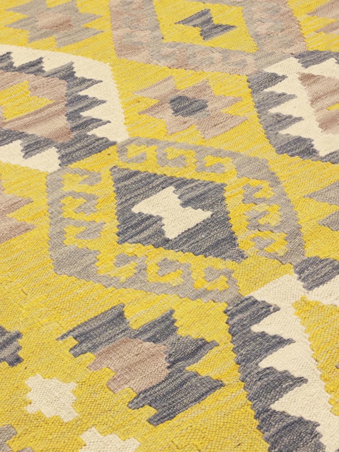 Tapis Kelim afghan tissé à la main présentant un champ jaune avec des motifs géométriques en losange