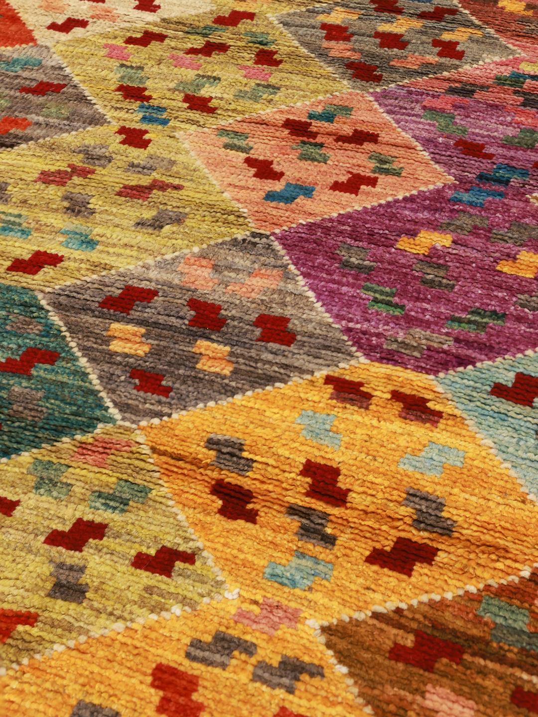 Een levendig Afghaans Berber vloerkleed met een geometrisch ruitpatroon in veelkleurige wol