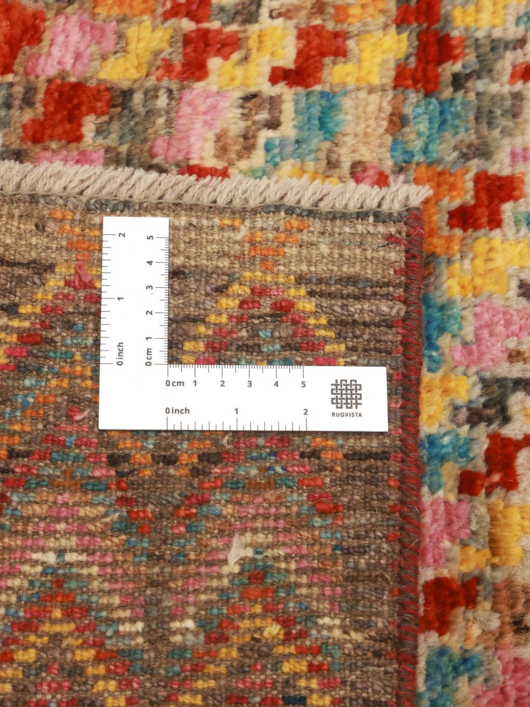 Et levende og farverigt håndknyttet tæppe fra Afghanistan med geometriske mønstre.