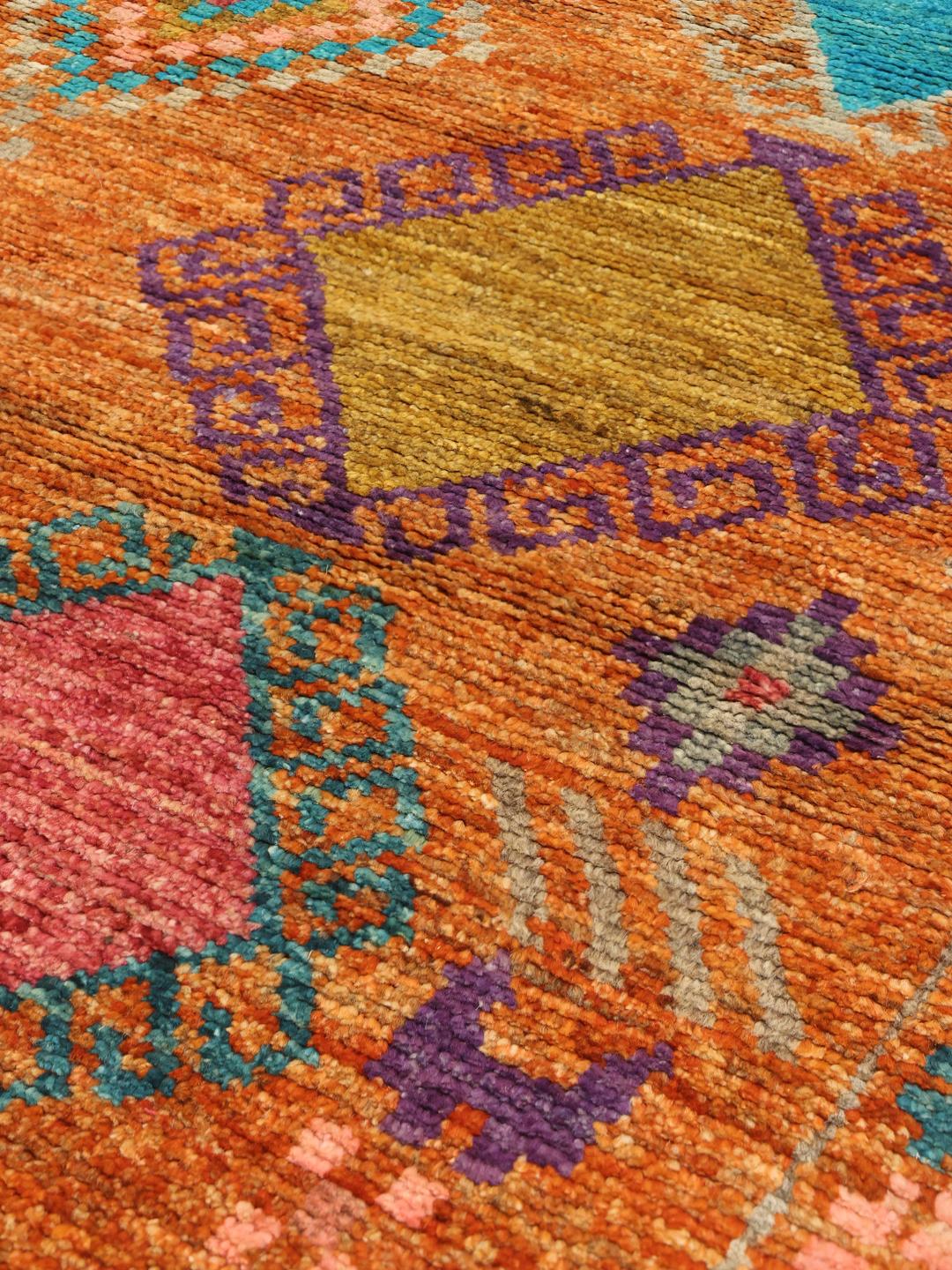 Met de hand geknoopt Afghaans tapijt met een kleurrijk geometrisch patroon op een warme achtergrond