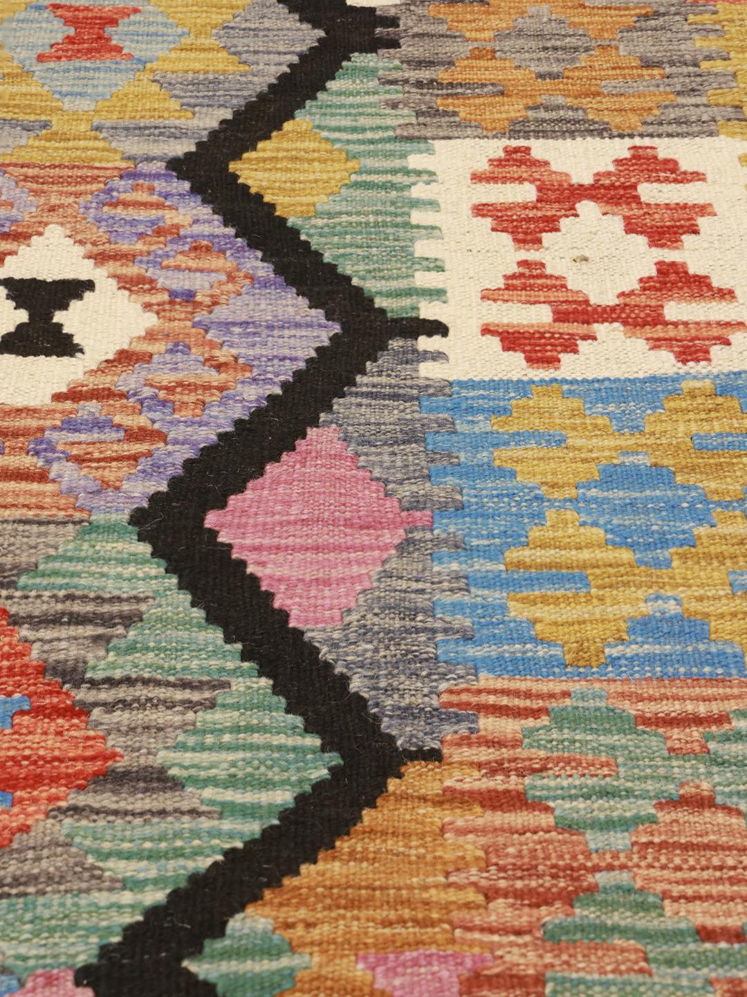 A vibrant, hand-woven Afghan Kelim rug featuring a bold diamond pattern in multicolor wool.