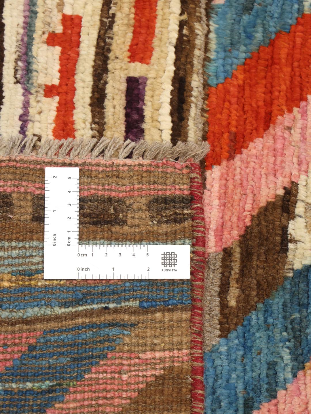 Et levende håndknyttet tæppe fra Afghanistan med farverige geometriske chevron-mønstre.