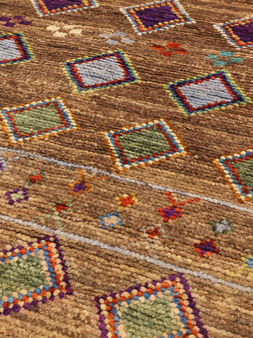 Handgeknoopt Afghaans tapijt met kleurrijke geometrische ruiten op een bruine achtergrond.