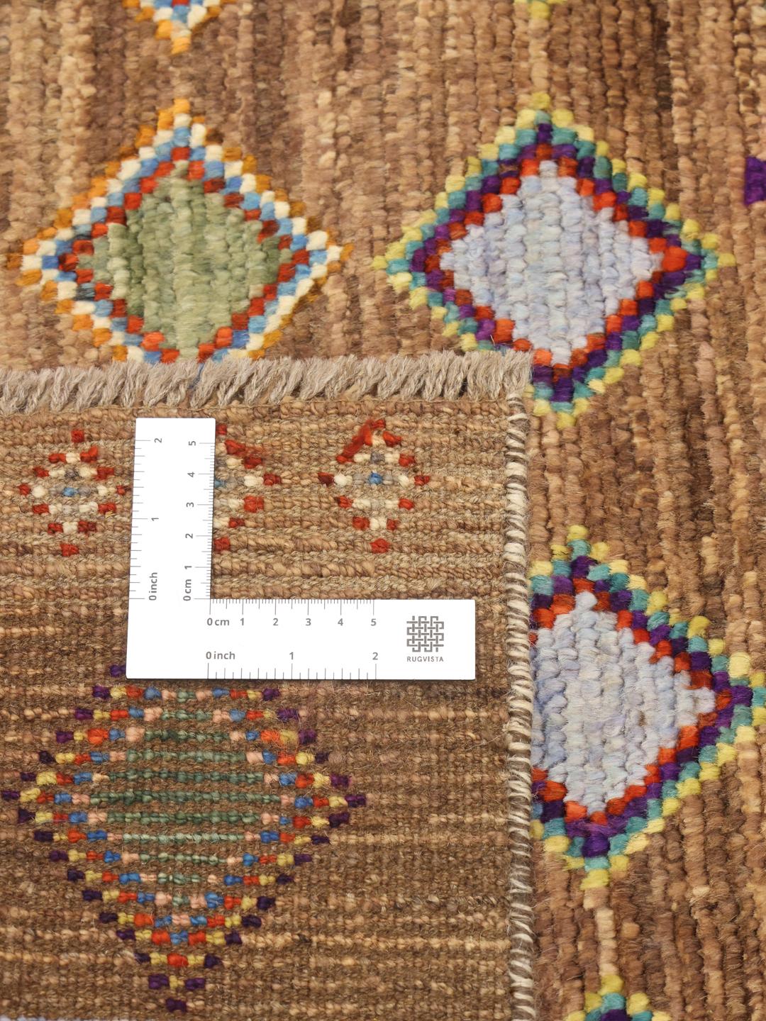 Handgeknoopt Afghaans tapijt met kleurrijke geometrische ruiten op een bruine achtergrond.