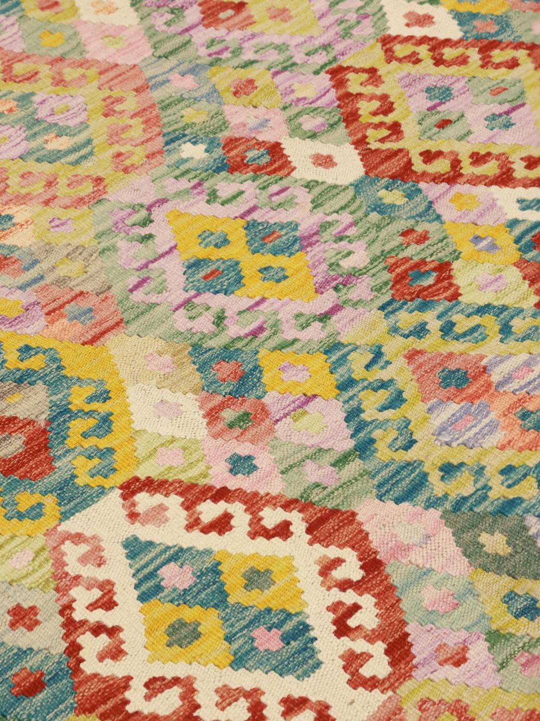 A hand-woven, multicolored Afghan Kelim rug with intricate geometric diamond patterns.