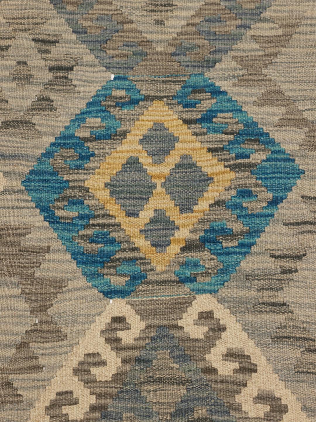Hand-woven Afghan Kelim rug with geometric patterns in blue, beige, and grey