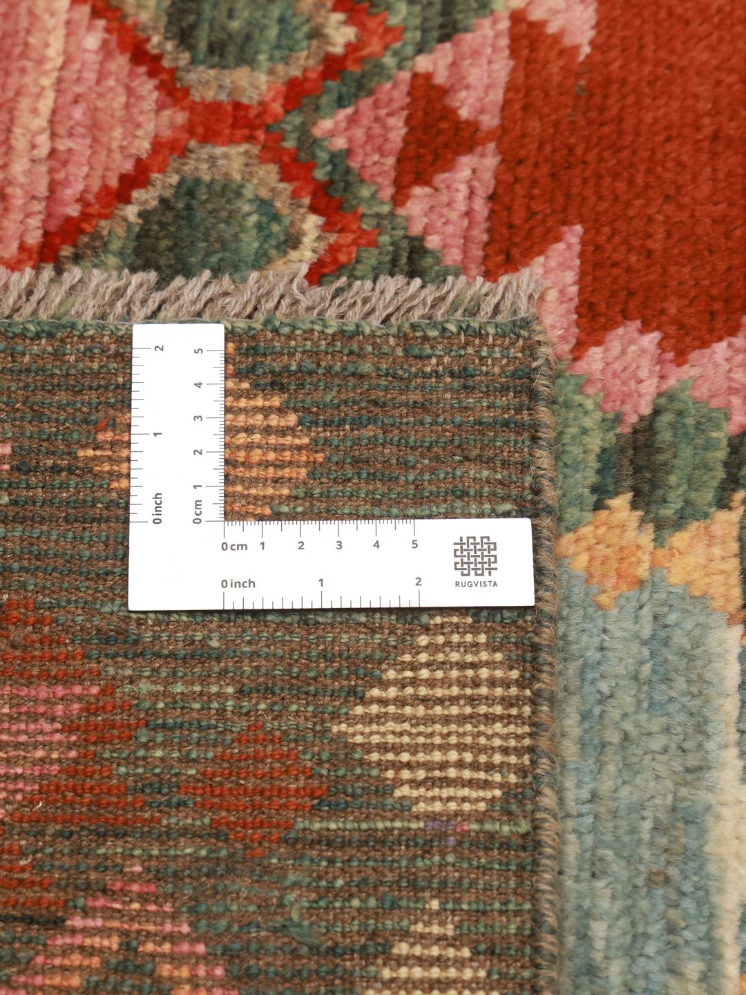 Een rechthoekig Berber Colourful tapijt uit Afghanistan met een donkergroene achtergrond en geometrische patronen.