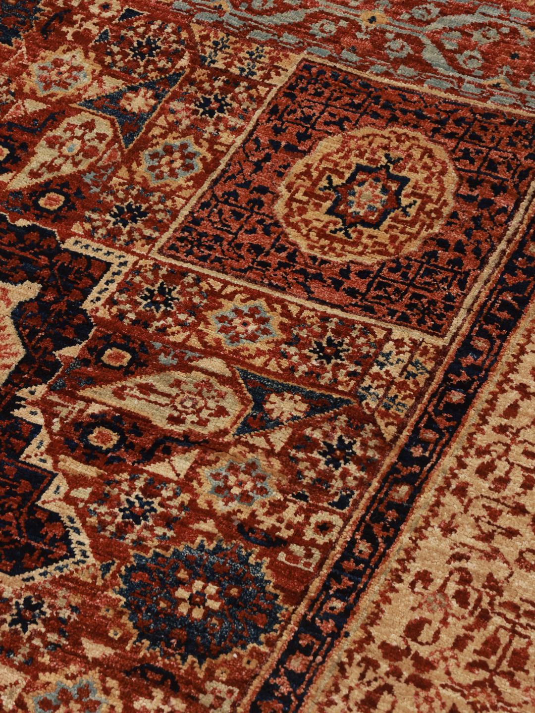 Et håndknyttet Mamluk-tæppe fra Afghanistan i røde og beige toner.