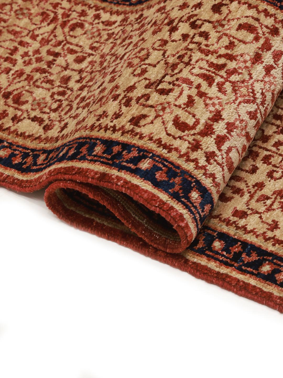 Et håndknyttet Mamluk-tæppe fra Afghanistan i røde og beige toner.