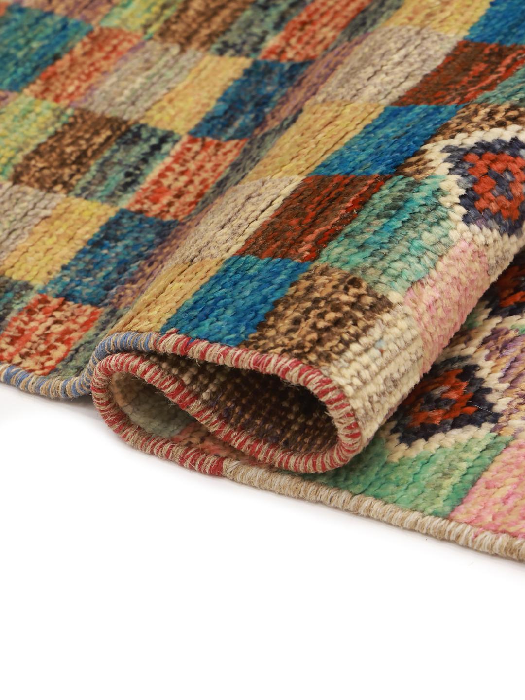 Et farverigt, håndknyttet Berber-tæppe fra Afghanistan med geometriske motiver og et ternet mønster.