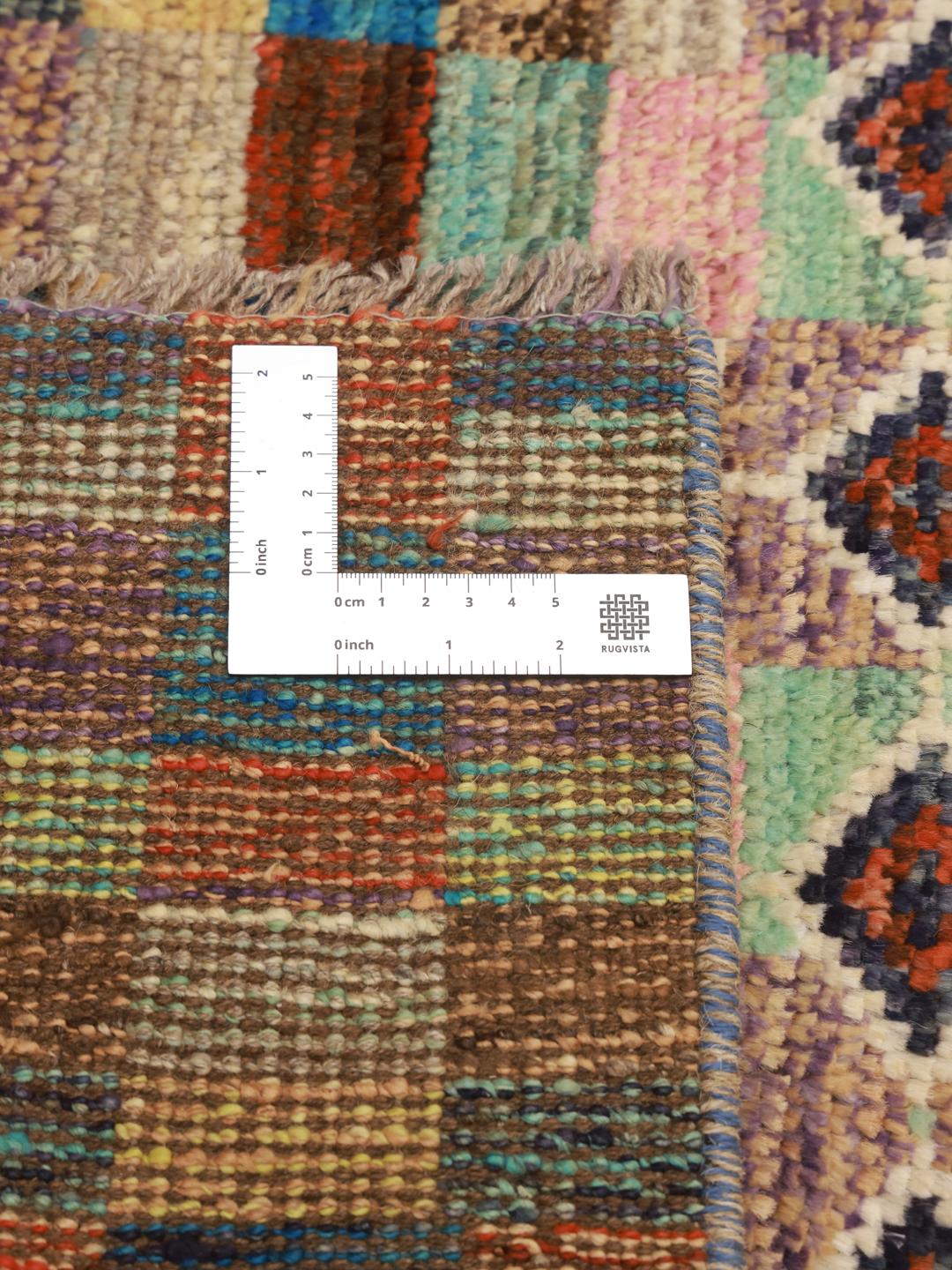 Et farverigt, håndknyttet Berber-tæppe fra Afghanistan med geometriske motiver og et ternet mønster.