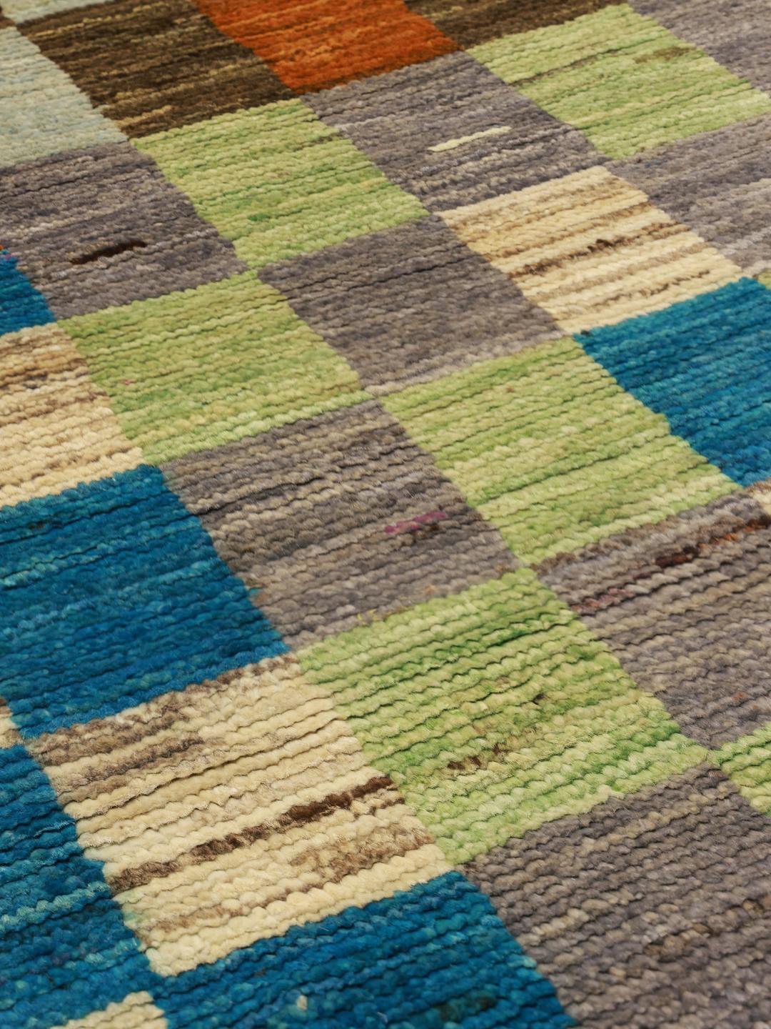 A vibrant, checkered hand-knotted wool runner rug from the Middle East in multicolor tones.