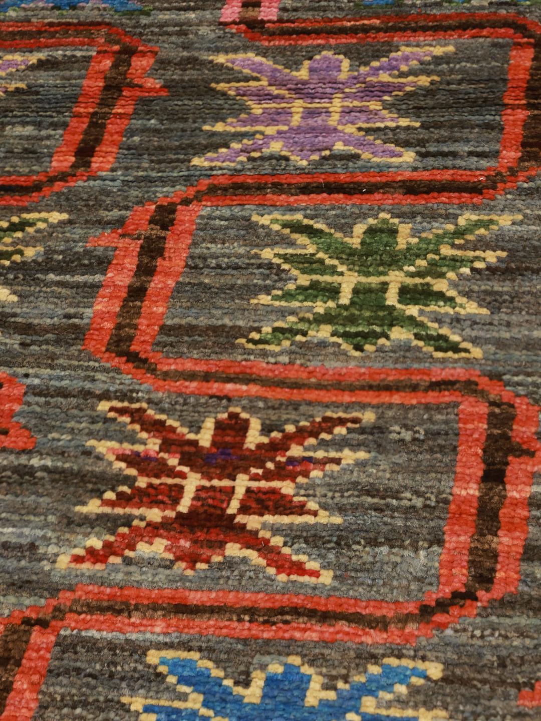 Hand-knotted Middle Eastern runner with a colourful pattern on a grey background
