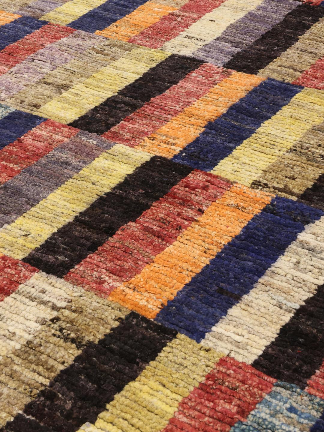 A vibrant, multi-coloured hand-knotted rug from Afghanistan with a block pattern.