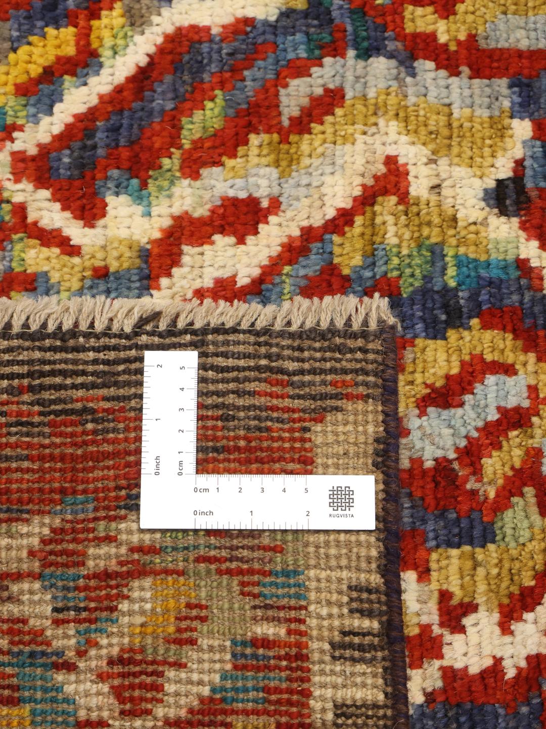 Een meerkleurig, handgeknoopt tapijt in Berber-stijl uit Afghanistan met een energiek, vloeiend patroon.