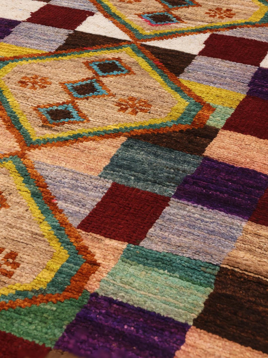 Hand-knotted Afghan runner with vibrant geometric diamond motifs and multicolor squares.