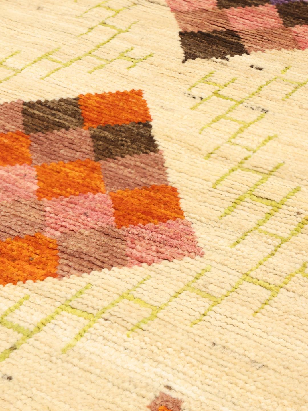 Hand-knotted Afghan rug with colourful geometric diamonds on a beige background.