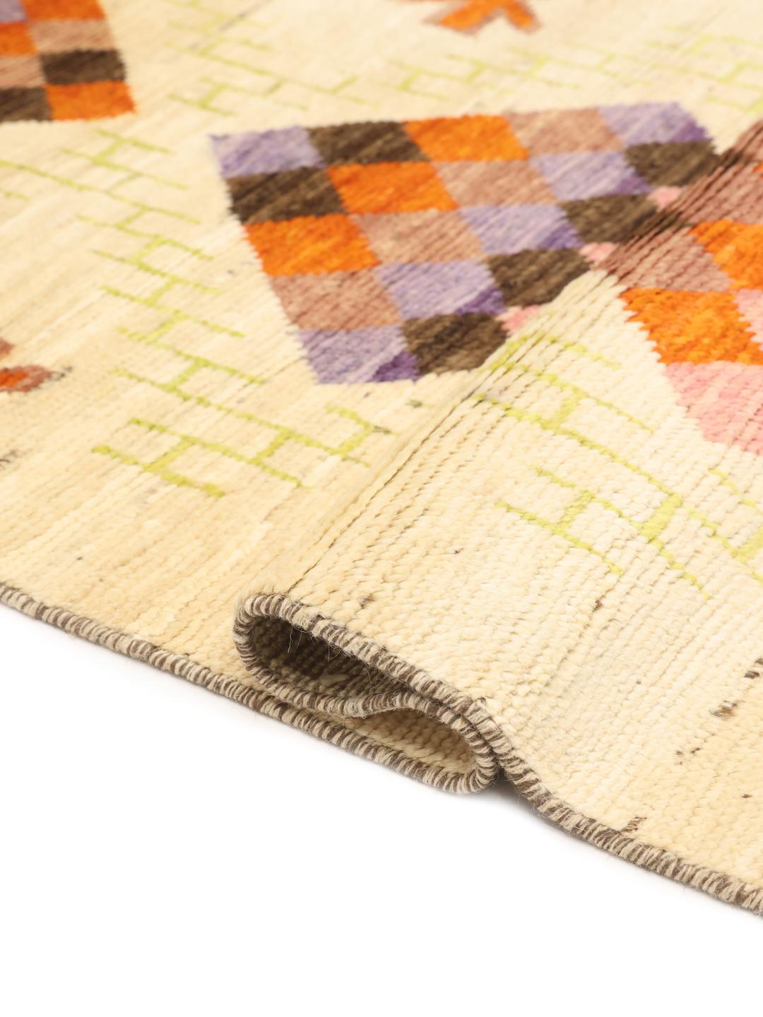 Hand-knotted Afghan rug with colourful geometric diamonds on a beige background.