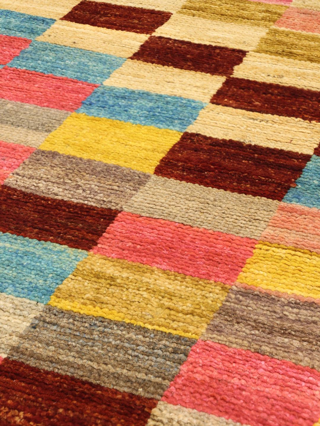A colourful hand-knotted Afghan runner rug with a vibrant checkerboard pattern